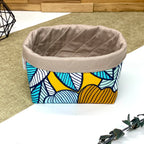 Panière de rangement textile artisanale à motif feuilles bleu pétrole, turquoise et jaune moutarde, idéale pour organiser accessoires, cosmétiques ou lingettes lavables.