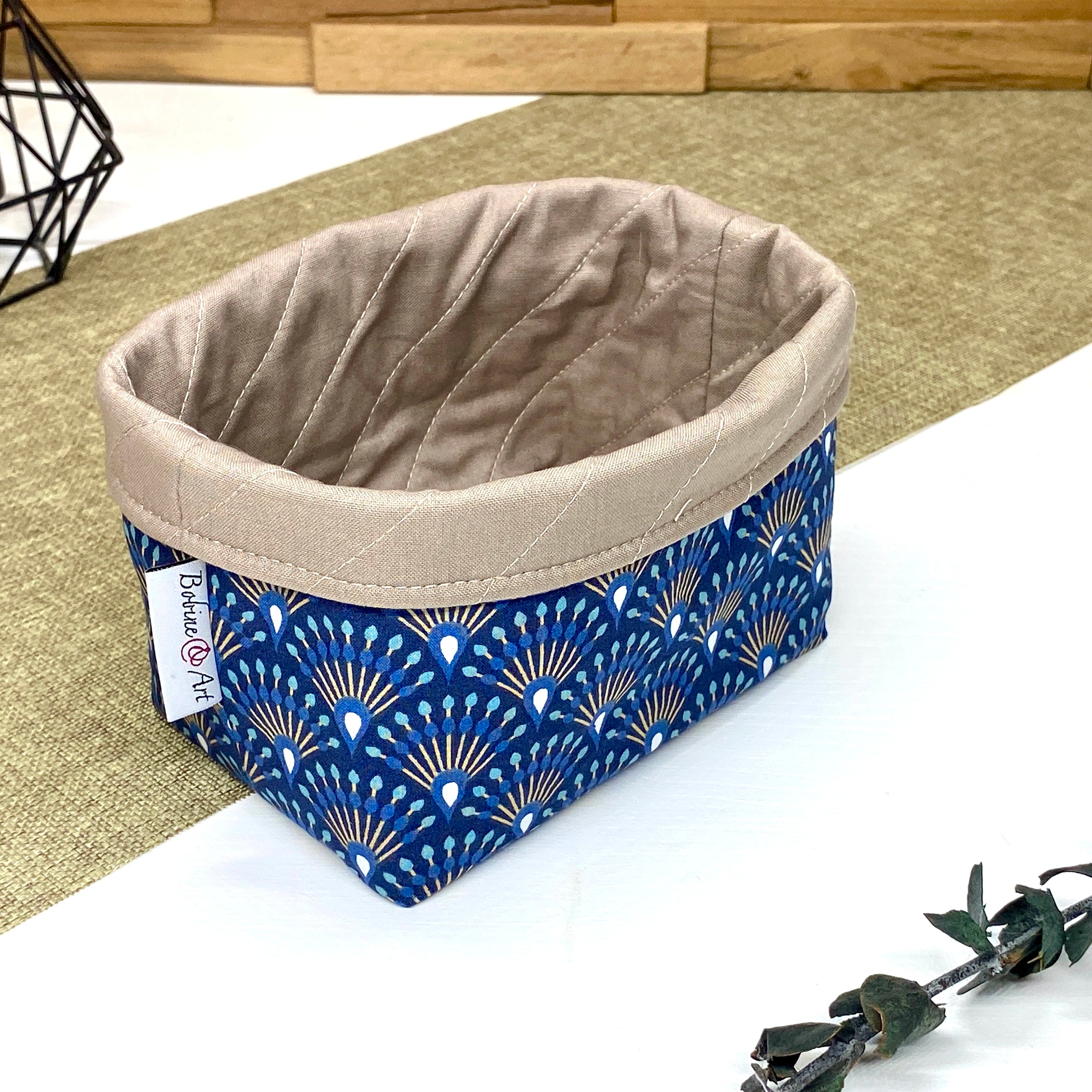 Panière de rangement textile artisanale à motif Art déco bleu et beige, idéale pour organiser cosmétiques, accessoires ou lingettes lavables.