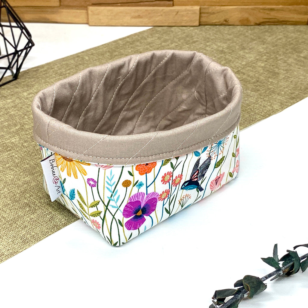 Panière de rangement textile artisanale à motif oiseaux et fleurs sauvages multicolores, idéale pour organiser cosmétiques, accessoires ou lingettes lavables.
