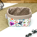 Panière de rangement textile artisanale à motif oiseaux et fleurs sauvages multicolores, idéale pour organiser cosmétiques, accessoires ou lingettes lavables.