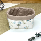 Panière de rangement textile artisanale à motif roses bleues vintage sur fond écru, idéale pour organiser cosmétiques, accessoires ou lingettes lavables.