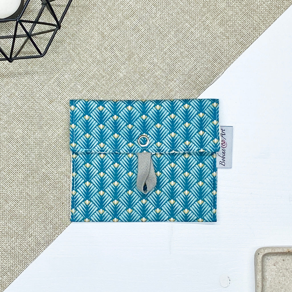 Porte-savon nomade imperméable fermé à motif éventails géométriques bleu canard, vert d’eau et beige, format compact idéal pour transporter un savon solide lors des déplacements, voyages ou activités du quotidien.