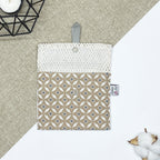 Porte-savon nomade imperméable ouvert avec filet respirant et motif géométrique beige et écru, idéal pour transporter, faire sécher et conserver un savon solide lors des déplacements et voyages.