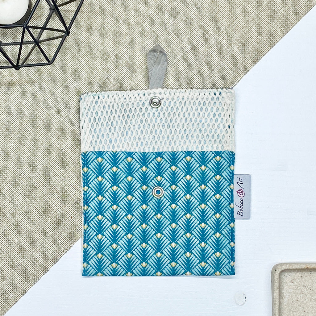 Porte-savon nomade imperméable ouvert avec filet respirant et motif éventails géométriques bleu canard, vert d’eau et beige, idéal pour transporter, faire sécher et conserver un savon solide lors des déplacements et voyages.
