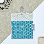 Porte-savon nomade imperméable ouvert avec filet respirant et motif éventails géométriques bleu canard, vert d’eau et beige, idéal pour transporter, faire sécher et conserver un savon solide lors des déplacements et voyages.