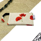 Trousse de toilette artisanale fermée en tissu avec motif coquelicots rouges et double compartiment imperméable.