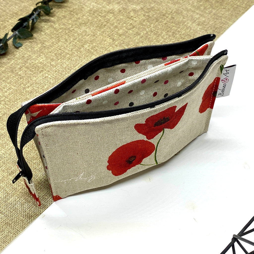 Trousse de toilette artisanale ouverte en tissu avec motif coquelicots rouges, double compartiment et intérieur imperméable.