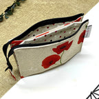 Trousse de toilette artisanale ouverte en tissu avec motif coquelicots rouges, double compartiment et intérieur imperméable.