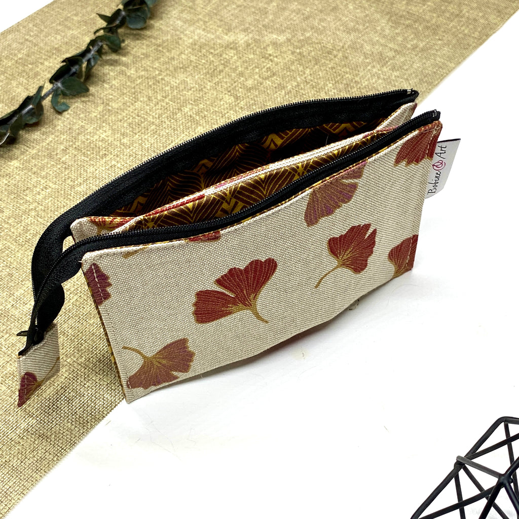 Trousse de toilette artisanale ouverte en tissu avec motif feuilles de ginkgo, double compartiment et intérieur imperméable.