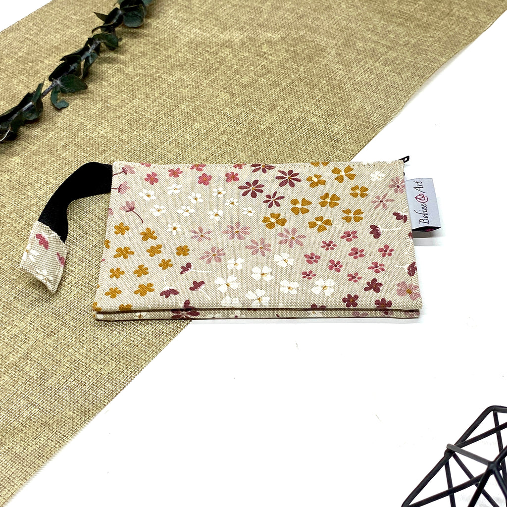 Trousse de toilette artisanale fermée en tissu avec motif fleurs champêtres multicolores et double compartiment imperméable.