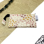 Trousse de toilette artisanale fermée en tissu avec motif fleurs champêtres multicolores et double compartiment imperméable.