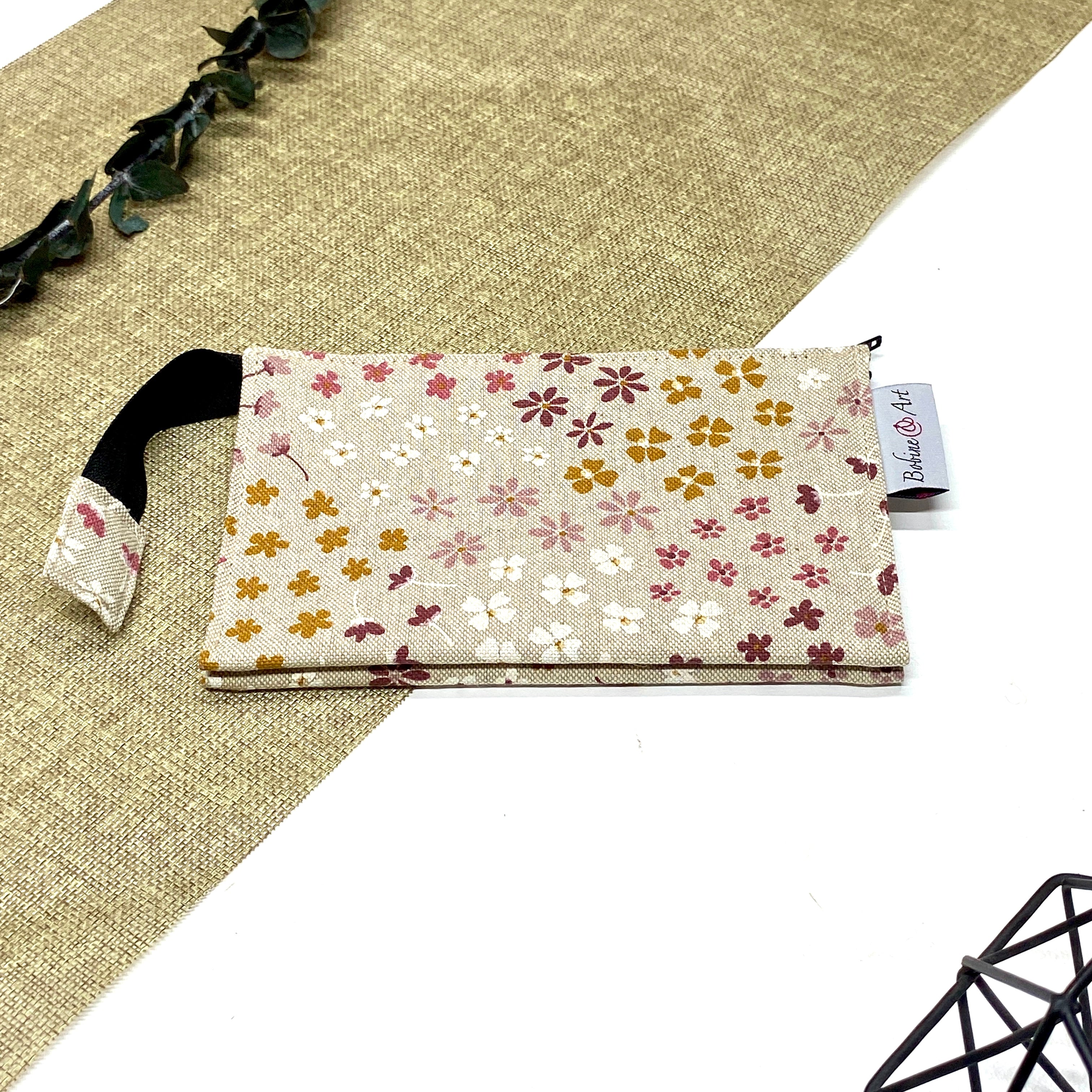 Trousse de toilette artisanale fermée en tissu avec motif fleurs champêtres multicolores et double compartiment imperméable.