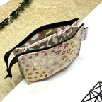 Trousse de toilette artisanale ouverte en tissu avec motif fleurs champêtres, double compartiment et intérieur imperméable.