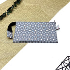 Trousse de toilette artisanale fermée en tissu avec motif géométrique gris et blanc et double compartiment imperméable.