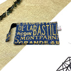 Trousse de toilette artisanale fermée en tissu avec motif Paris vintage typographique et double compartiment imperméable.