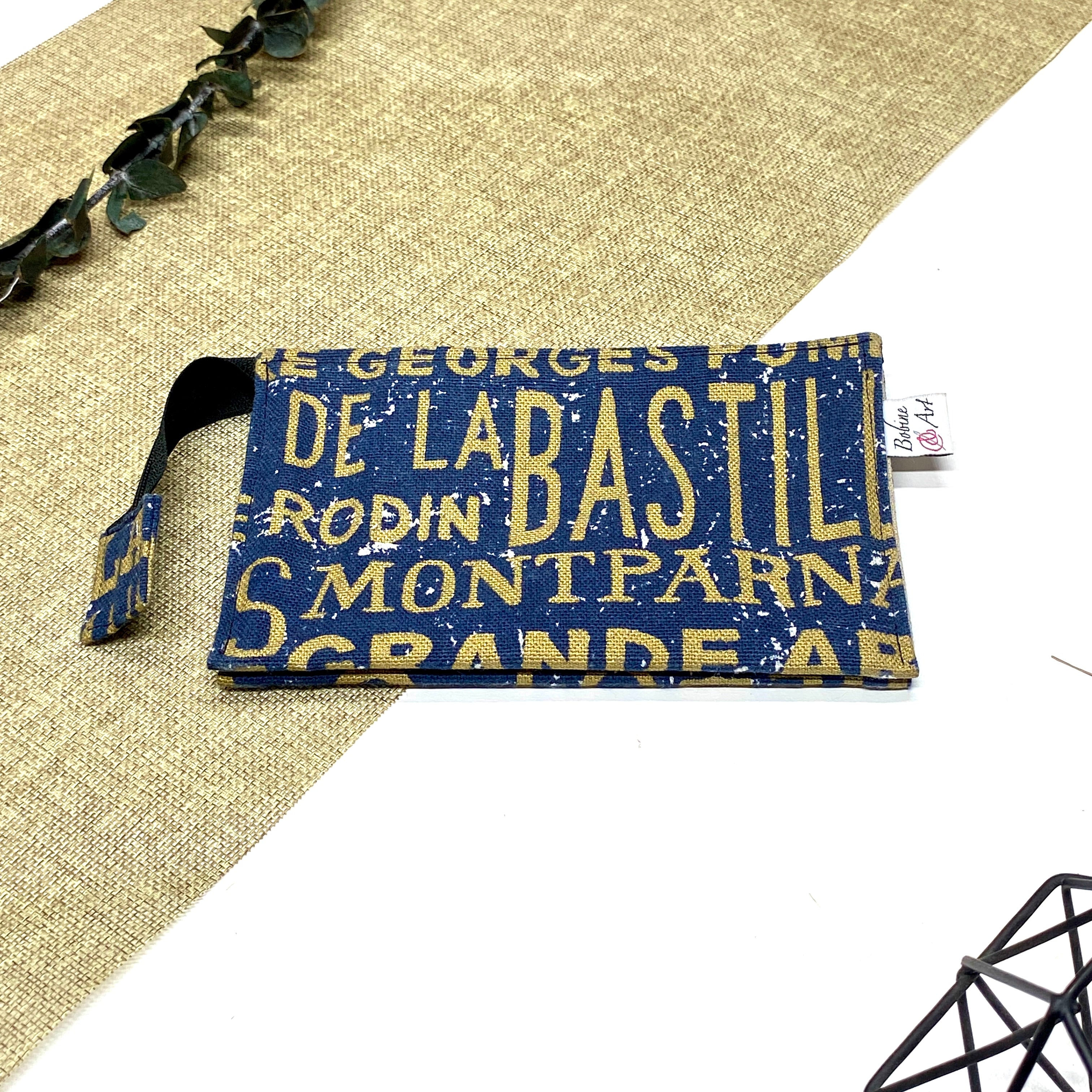 Trousse de toilette artisanale fermée en tissu avec motif Paris vintage typographique et double compartiment imperméable.