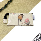 Trousse de toilette artisanale fermée en tissu avec motif oiseau sur branche fleurie et double compartiment imperméable.
