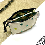 Trousse de toilette artisanale en tissu avec double compartiment imperméable et motif pois verts.